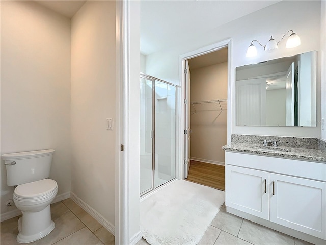 bathroom featuring tile patterned flooring, vanity, and walk in shower