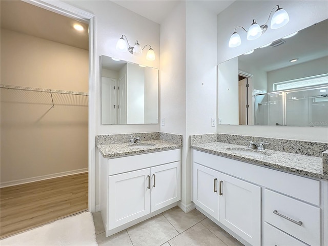 bathroom featuring vanity, an enclosed shower, and tile patterned floors