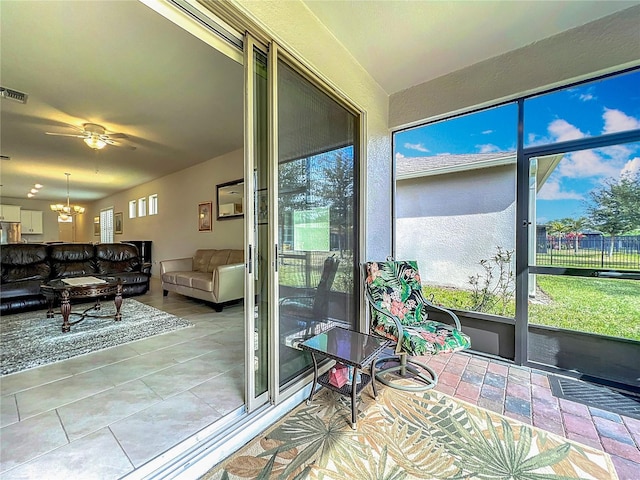 sunroom / solarium with ceiling fan with notable chandelier