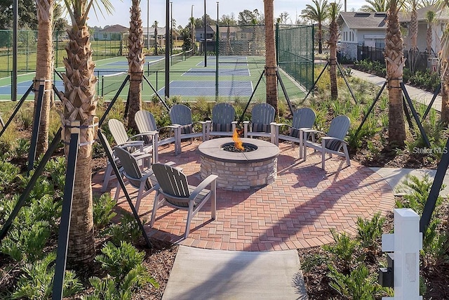 view of patio with tennis court and an outdoor fire pit