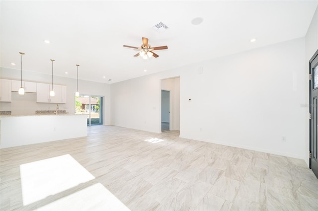 unfurnished living room featuring sink and ceiling fan