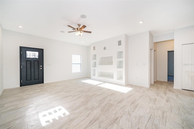 unfurnished living room with built in features and ceiling fan