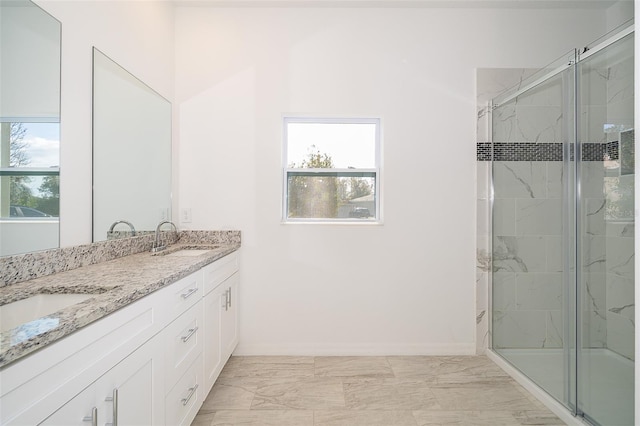 bathroom featuring plenty of natural light, a shower with door, and vanity