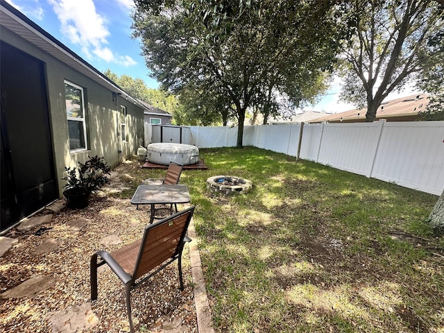 view of yard featuring a hot tub and an outdoor fire pit