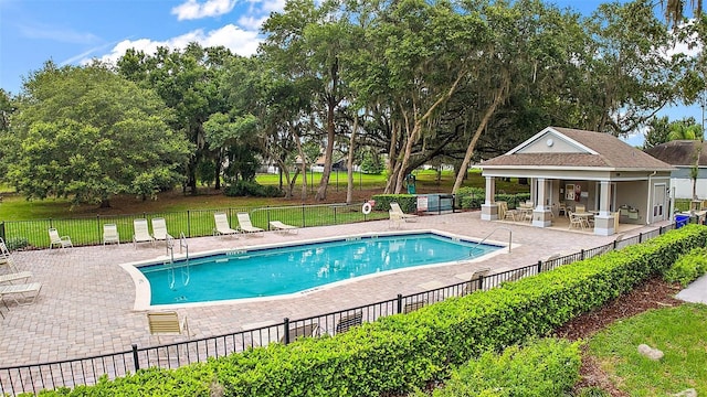 view of pool with a patio and an outdoor structure