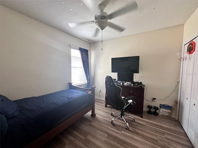 bedroom featuring hardwood / wood-style floors, a textured ceiling, and ceiling fan