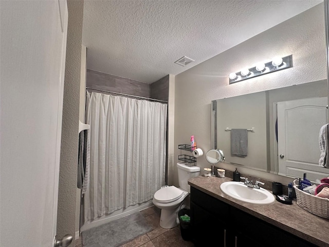 bathroom featuring vanity, tile patterned flooring, toilet, and a textured ceiling