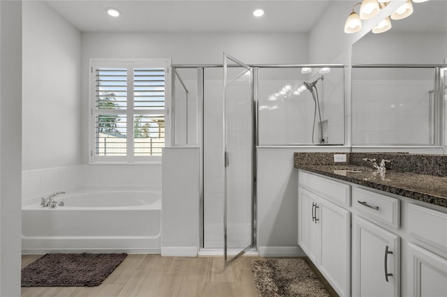 bathroom featuring independent shower and bath, vanity, and hardwood / wood-style floors