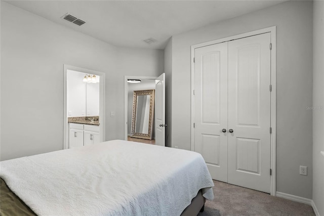 bedroom with light carpet, a closet, and ensuite bathroom