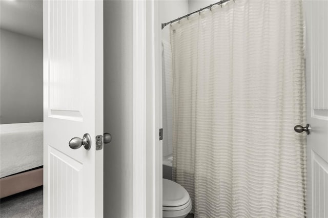 bathroom with shower / bath combo and toilet