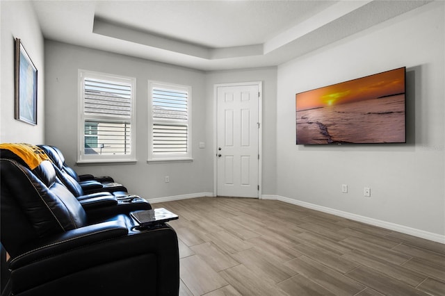 living area featuring a raised ceiling and hardwood / wood-style flooring