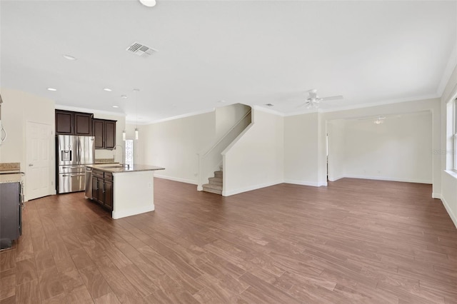 kitchen featuring sink, dark hardwood / wood-style flooring, a kitchen island with sink, dark brown cabinetry, and stainless steel refrigerator with ice dispenser