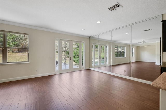 spare room with dark wood-type flooring, a healthy amount of sunlight, and french doors