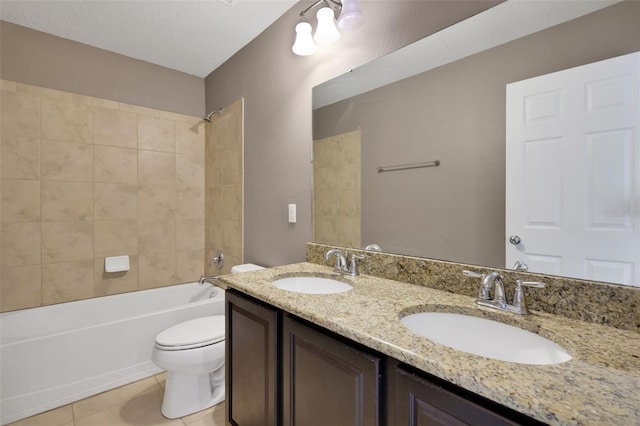 full bathroom with tiled shower / bath combo, vanity, a textured ceiling, tile patterned floors, and toilet