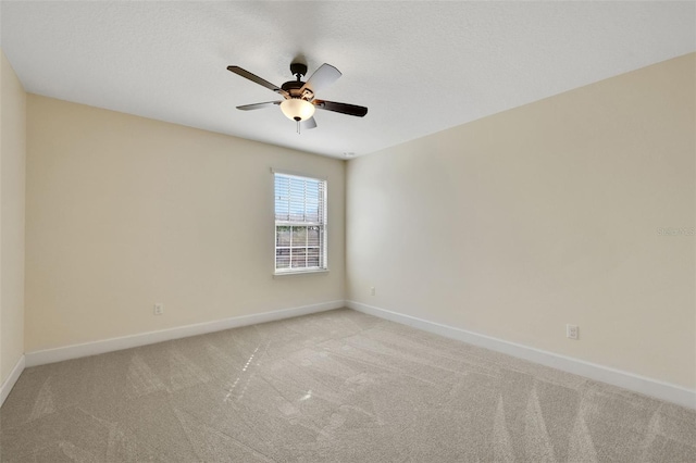 carpeted spare room with a textured ceiling and ceiling fan