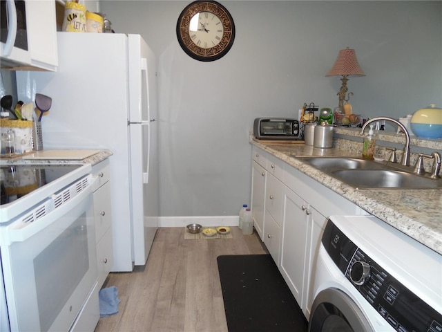 kitchen featuring washer / clothes dryer, sink, white cabinets, light hardwood / wood-style floors, and white appliances