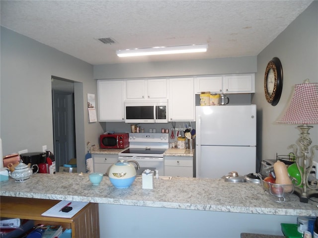 kitchen with white appliances, a textured ceiling, kitchen peninsula, and white cabinets