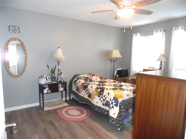 bedroom with ceiling fan, dark hardwood / wood-style floors, and a textured ceiling