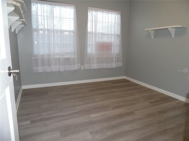 spare room featuring wood finished floors and baseboards