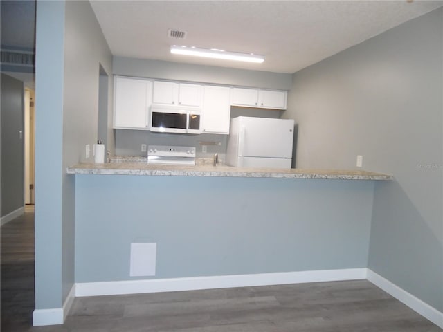 kitchen featuring freestanding refrigerator, stainless steel microwave, range, and a peninsula