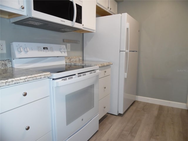 kitchen with light stone counters, light wood-style flooring, white appliances, baseboards, and white cabinets