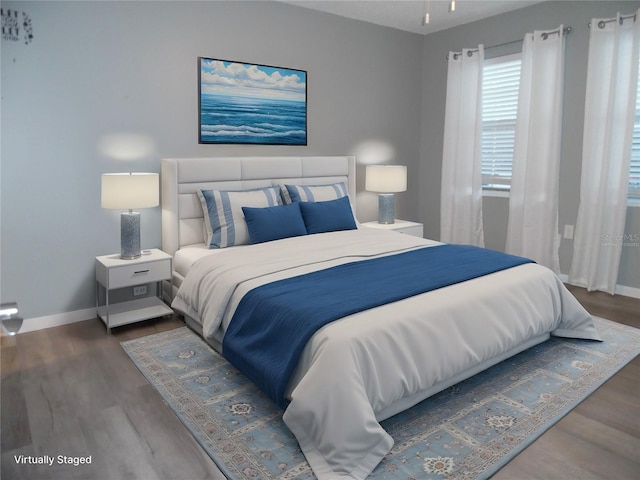 bedroom featuring wood finished floors and baseboards