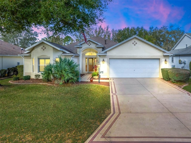 single story home with a garage, a front yard, driveway, and stucco siding