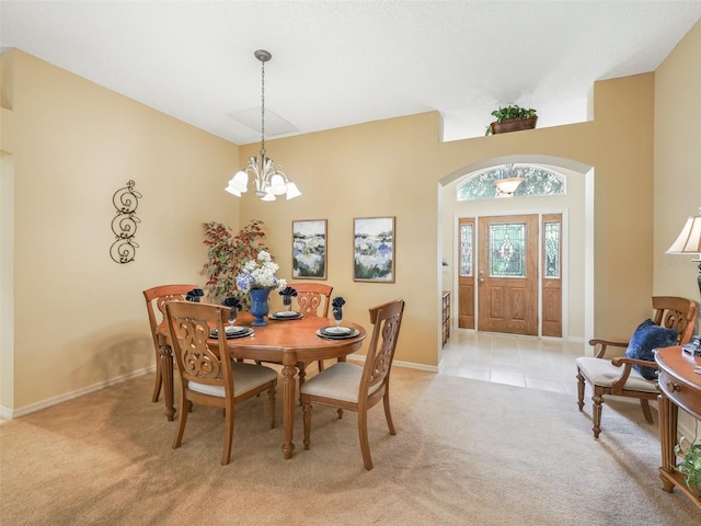 dining room with an inviting chandelier, light tile patterned floors, baseboards, and light colored carpet