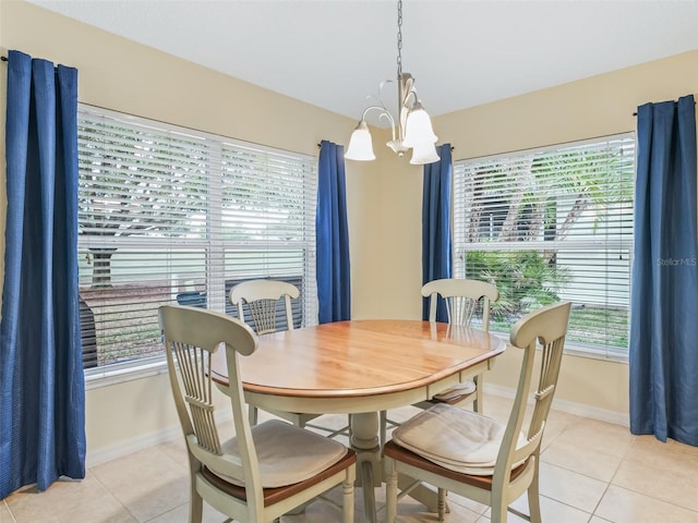 dining room featuring baseboards, a notable chandelier, and light tile patterned flooring