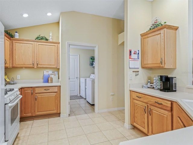 kitchen with lofted ceiling, light tile patterned floors, separate washer and dryer, light countertops, and white gas range oven