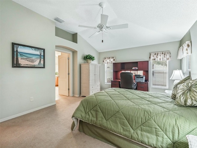 bedroom with light colored carpet, lofted ceiling, visible vents, and a textured ceiling