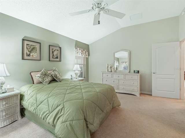 bedroom with a ceiling fan, light carpet, vaulted ceiling, and a textured ceiling