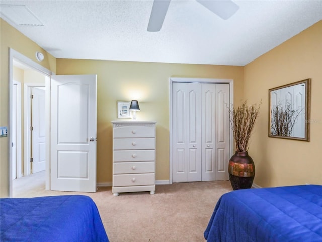 bedroom featuring a closet, visible vents, light carpet, ceiling fan, and a textured ceiling