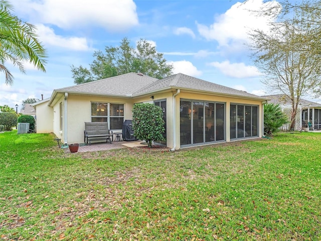 back of house with a lawn, a patio area, a sunroom, and stucco siding