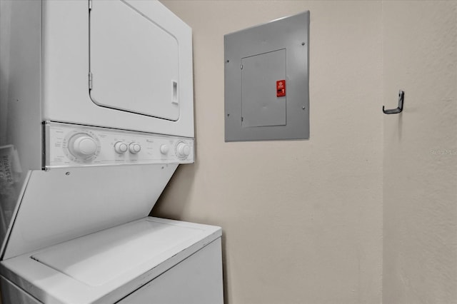 washroom with stacked washer and clothes dryer and electric panel