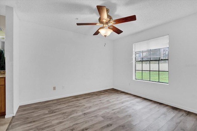 unfurnished room featuring ceiling fan, light hardwood / wood-style flooring, and a textured ceiling