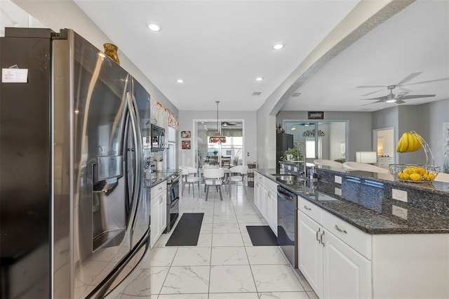 kitchen with pendant lighting, sink, appliances with stainless steel finishes, white cabinets, and dark stone counters