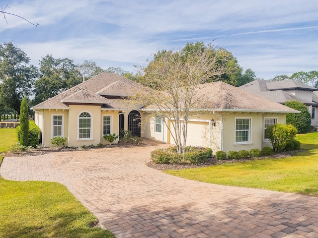 single story home with a garage and a front lawn