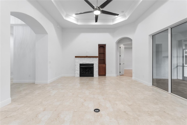 unfurnished living room featuring ceiling fan, ornamental molding, and a tray ceiling