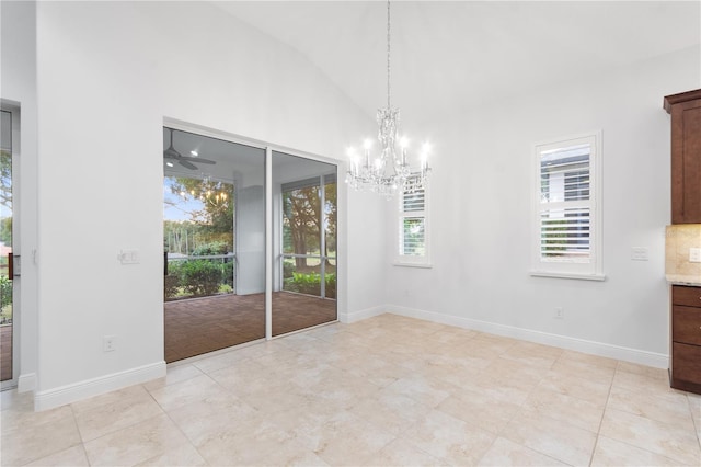 unfurnished dining area featuring light tile patterned floors, high vaulted ceiling, and a chandelier