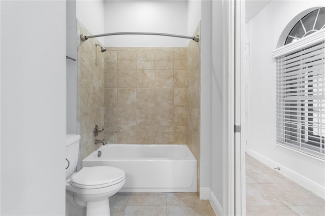 bathroom with tiled shower / bath, tile patterned floors, and toilet