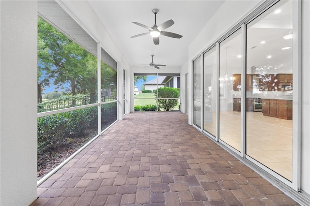 unfurnished sunroom with ceiling fan