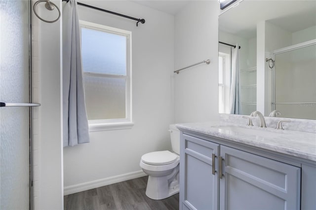 bathroom featuring hardwood / wood-style flooring, vanity, toilet, and an enclosed shower