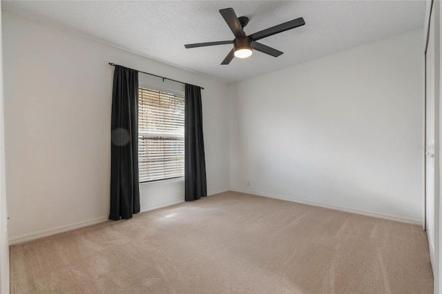 unfurnished room with light colored carpet, a textured ceiling, and ceiling fan