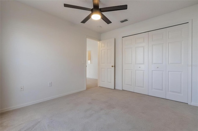 unfurnished bedroom featuring light carpet, a closet, and ceiling fan