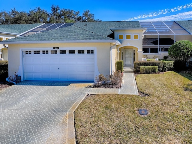 view of front property featuring a garage, glass enclosure, and a front yard