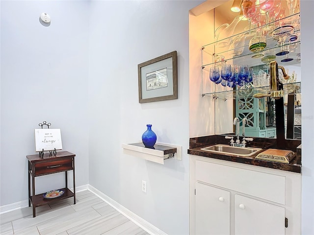 bar featuring white cabinetry and sink