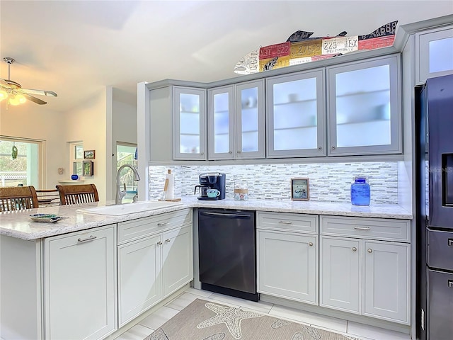 kitchen with dishwasher, sink, light stone counters, and kitchen peninsula