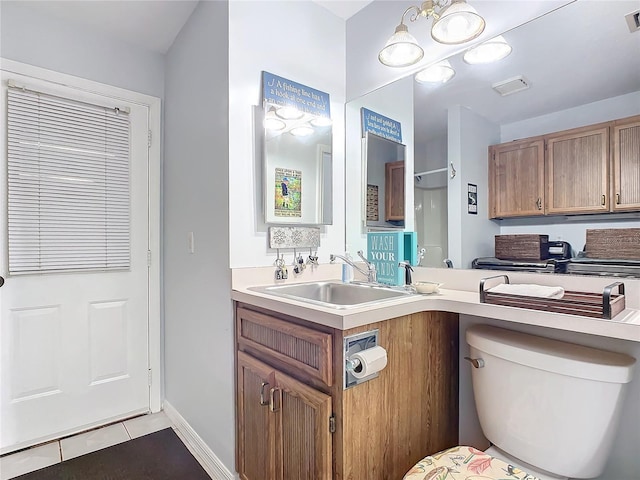 bathroom featuring vanity, toilet, and tile patterned flooring