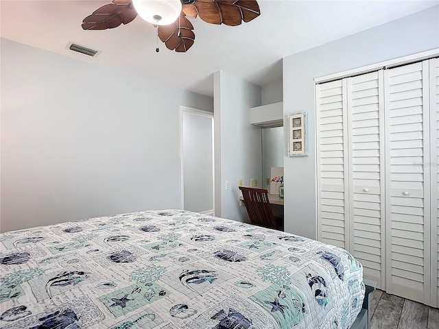 bedroom with ceiling fan, wood-type flooring, and a closet